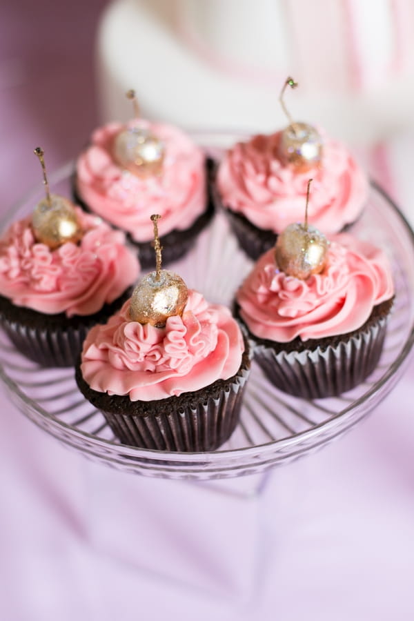 Pink cupcakes with gold cherries