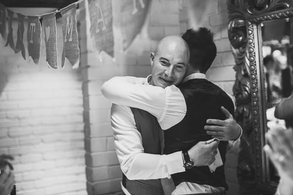 Groom and best man hug