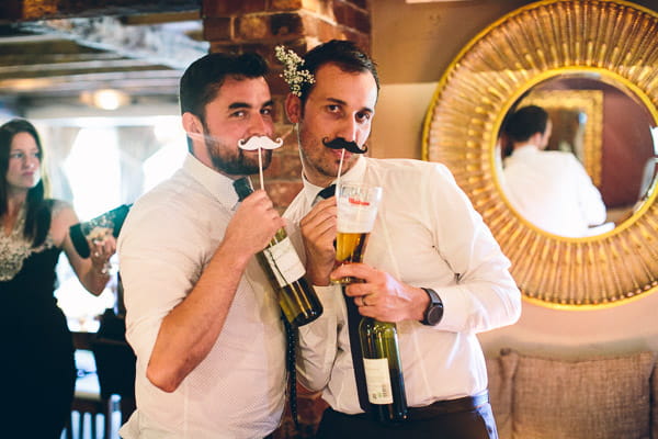 Wedding guests with moustaches on sticks