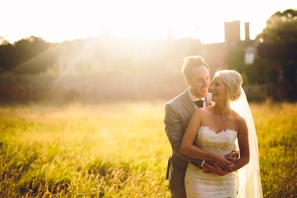 Groom with arms around bride's waist