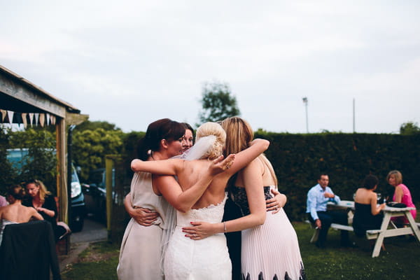 Bride and bridesmaids hugging