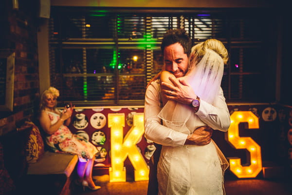 Bride and groom hug on dance floor