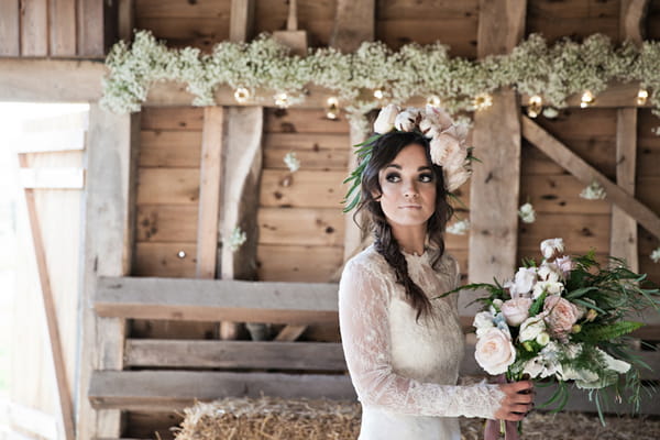 Bride with large floral headpiece holding bouquet