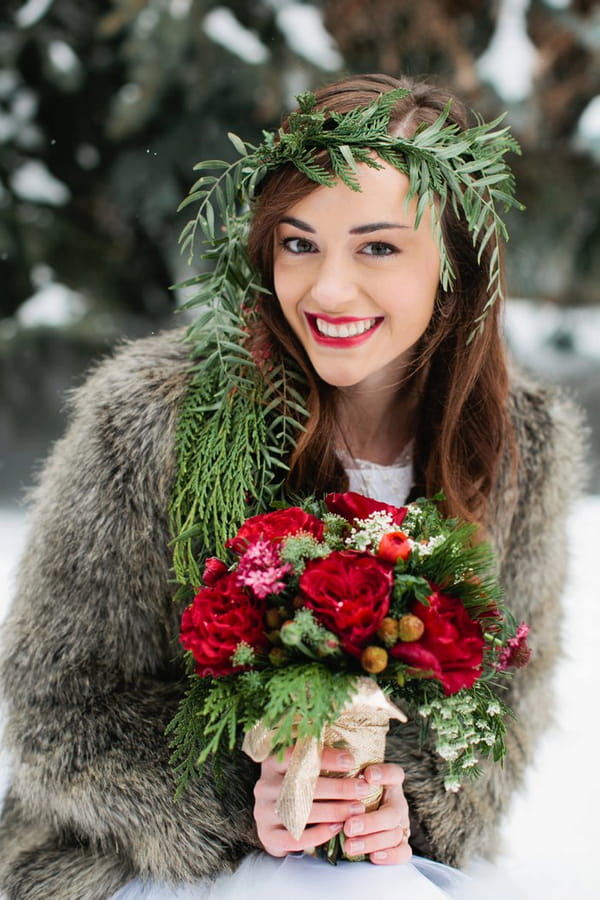 Bride with leaf headpiece holding Christmas wedding bouquet