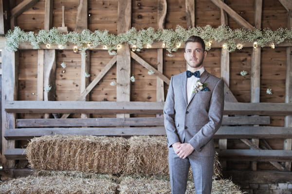 Groom standing in barn