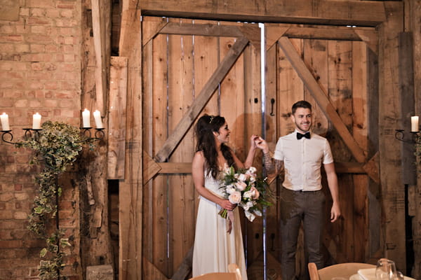 Bride and groom by barn door