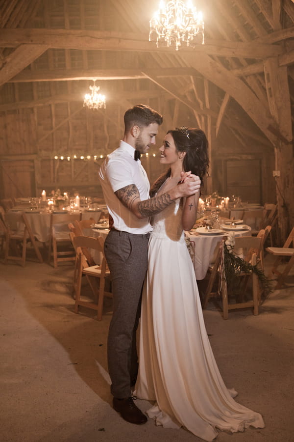 Bride and groom dance in barn