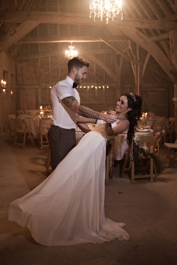 Bride and groom dance in barn