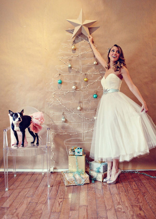 Bride reaching to put star on Christmas tree