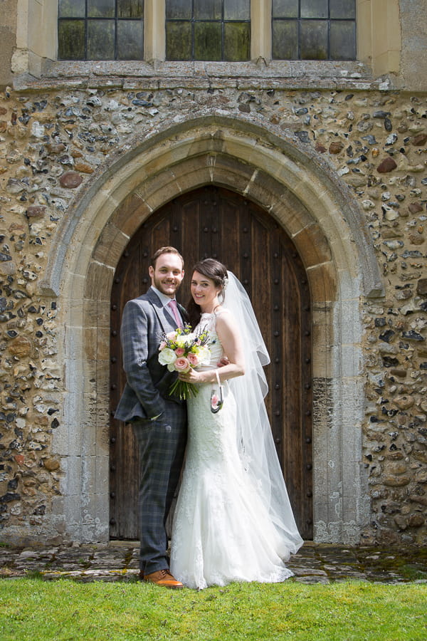 Bride and groom posing by church door