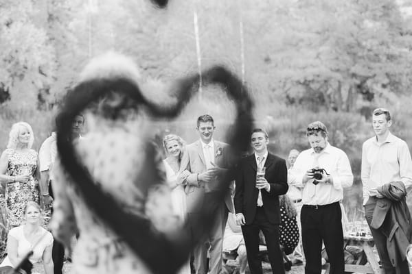 Bride and groom seen through hanging heart