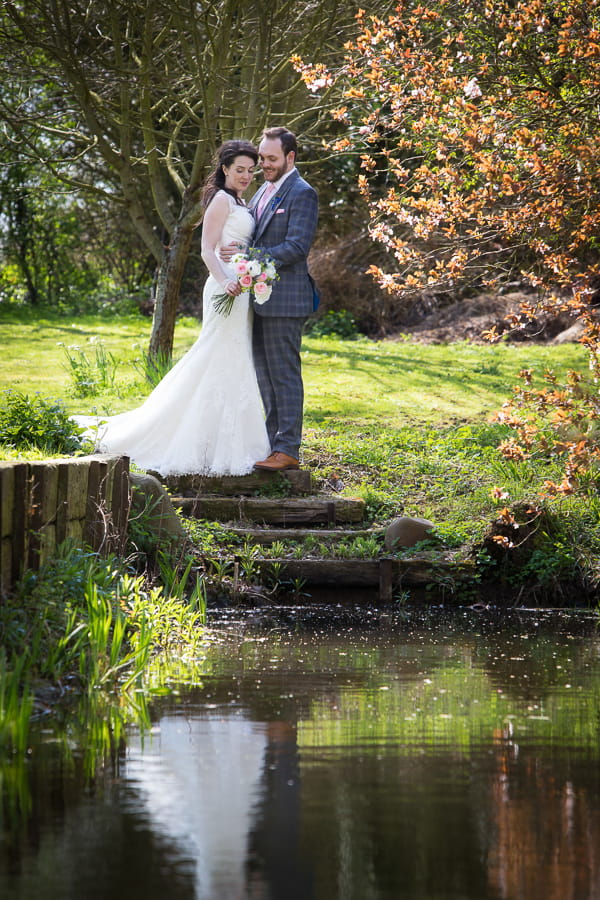 Bride and groom next to pond
