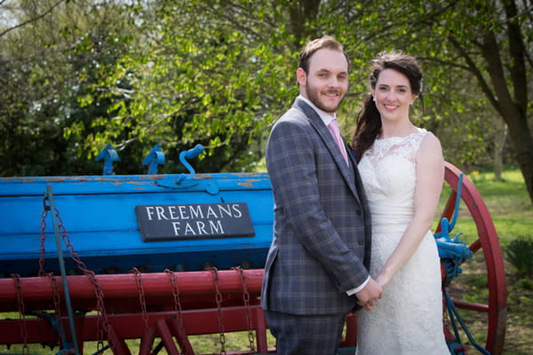 Bride and groom next to farm machinery