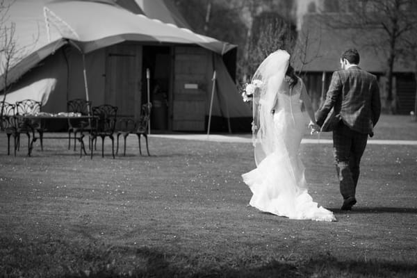 Bride and groom walking to tipi
