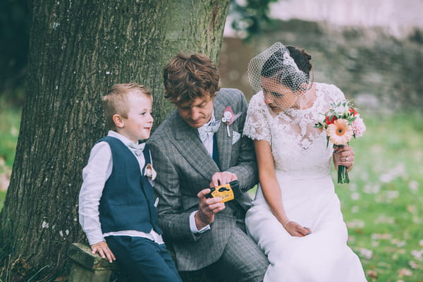 Bride and groom looking at picture with pageboy