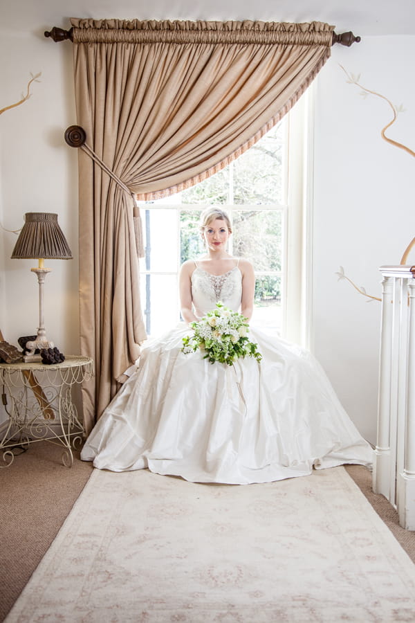 Bride sitting on window ledge