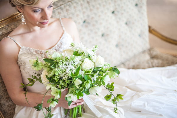 Bride sitting holding bouquet