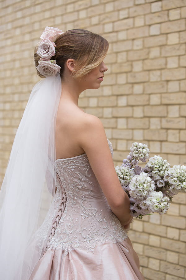 Bride with long veil holding bouquet