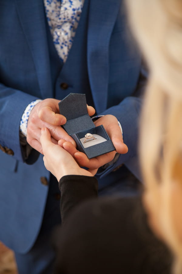 Man holding out engagement ring