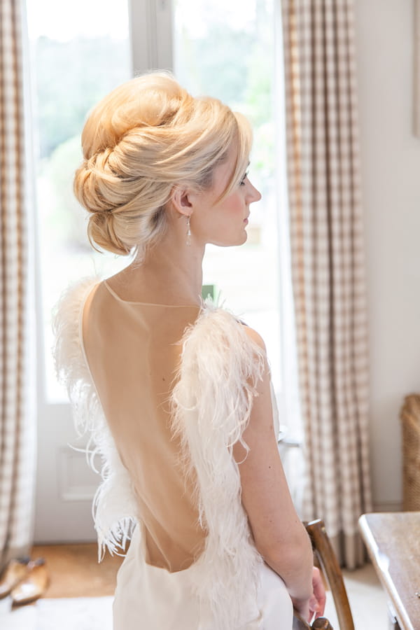 Bride wearing wedding dress with feather detail