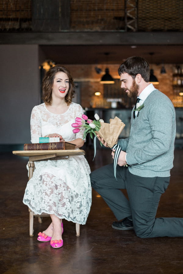 Man giving woman flowers at desk