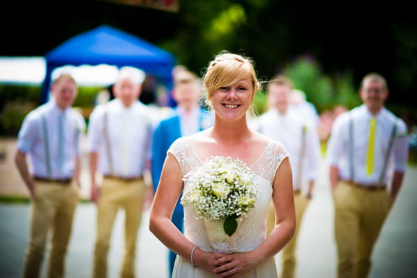 Bride standing in front of groomsmen