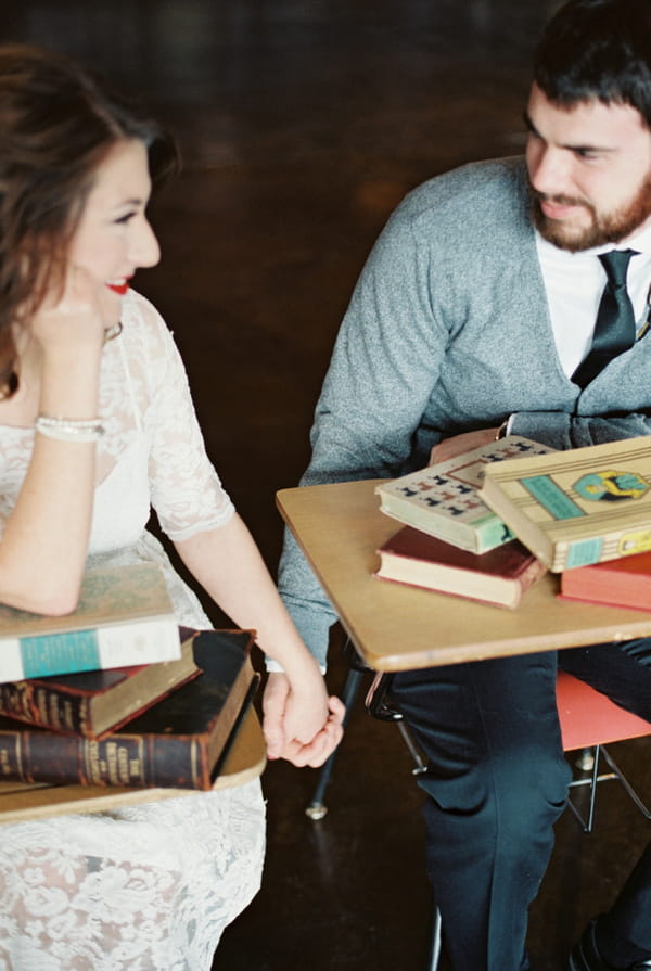 Couple holding hands at school desks