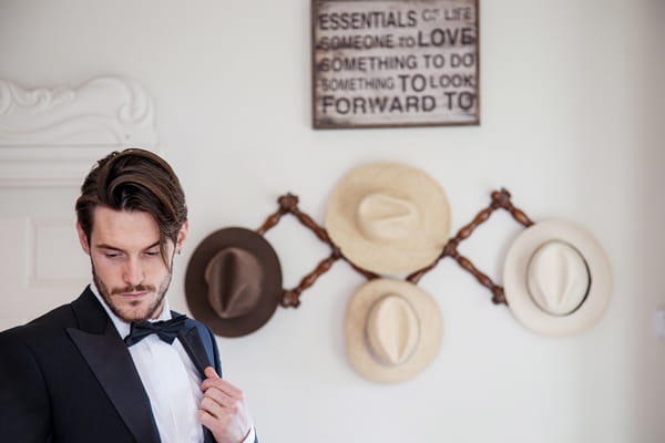 Han standing in front of hanging hats