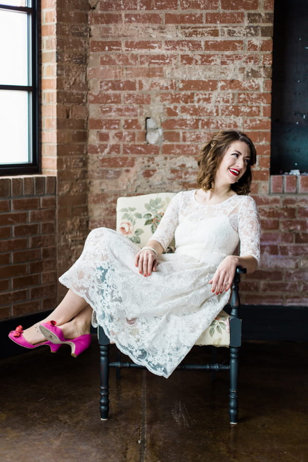 Bride with pink shoes sitting in chair