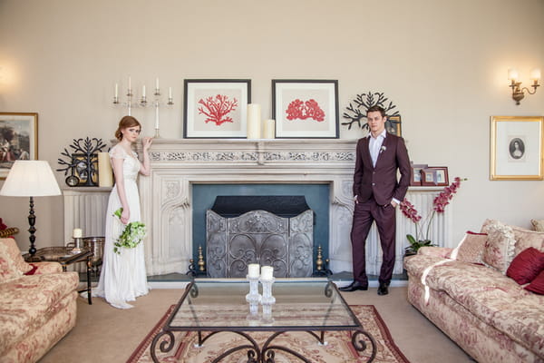 Bride and groom standing by fireplace