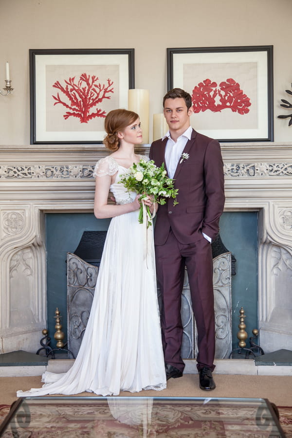 Bride and groom standing in front of fireplace