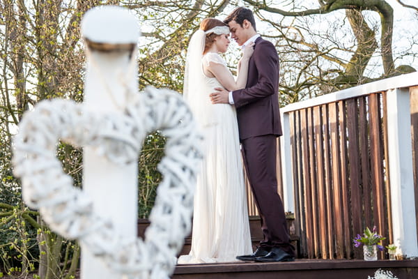 Bride and groom standing on wooden bridge