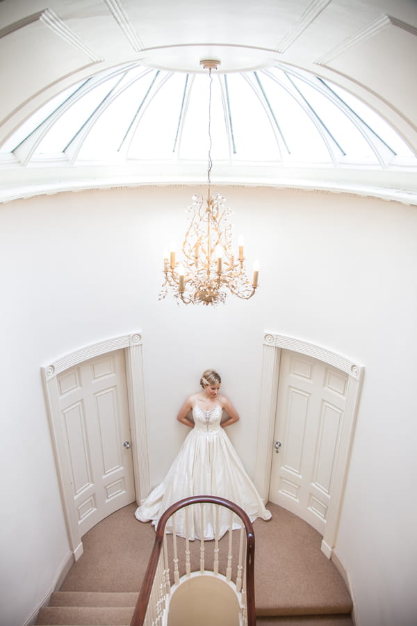 Bride standing at top of stairs in Ormesby Manor