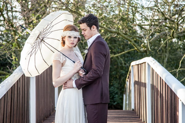 Bride and groom holding parasol