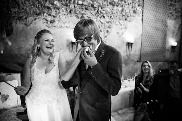 Groom eating wedding cake