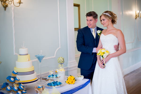 Bride and groom looking at cake table