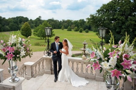 Bride and groom with venue flowers by Louise Avery Flowers