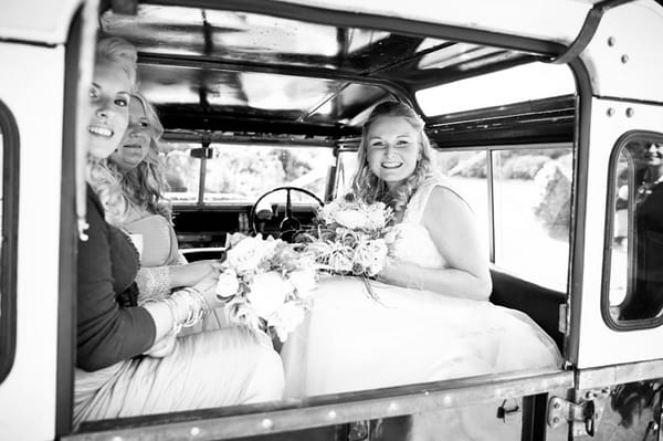 Bride and bridesmaids in back of Land Rover