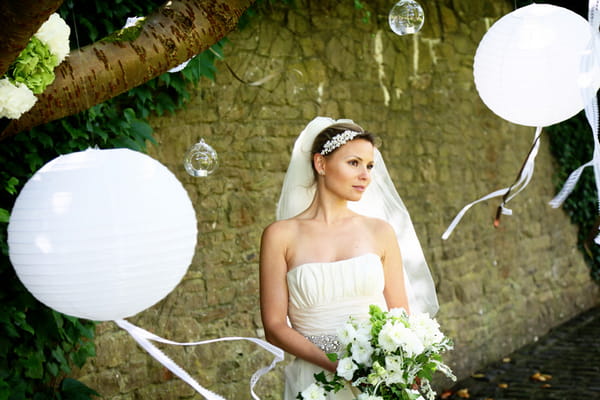 Bride holding bouquet next to balloons