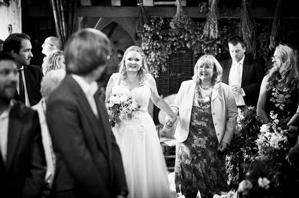 Mother walking bride down aisle