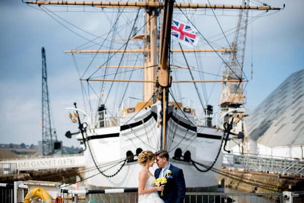 Bride and groom standing in front of boat at The Dockyard Chatham