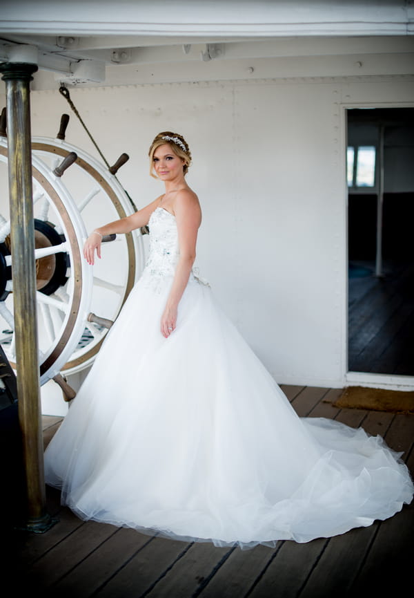 Bride standing at ship's wheel