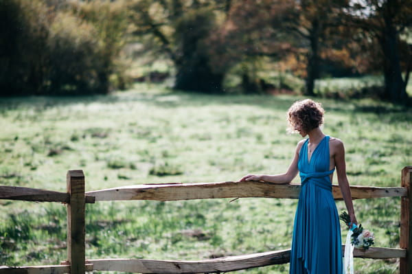 Bridesmaid standing next to fence