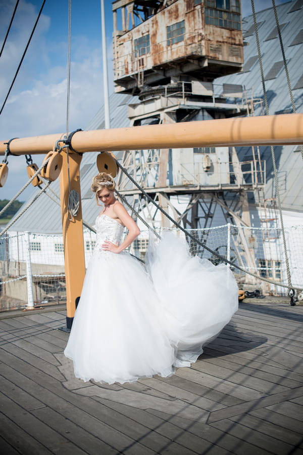 Bride on ship deck with dress blowing in wind