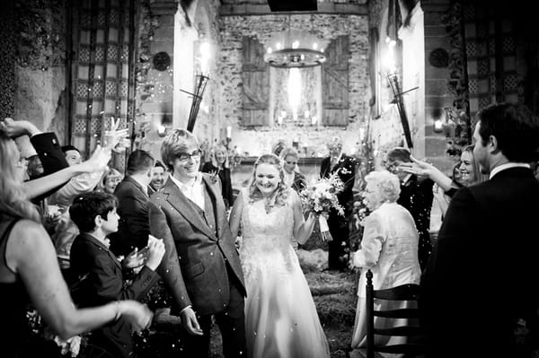 Confetti being thrown as bride and groom leave wedding ceremony