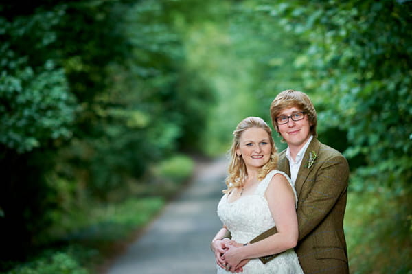 Groom with arms around bride's waist