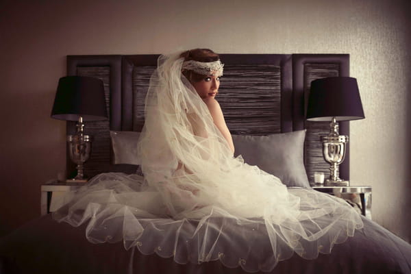 Bride in underwear and veil sitting on bed - Bridal boudoir shoot