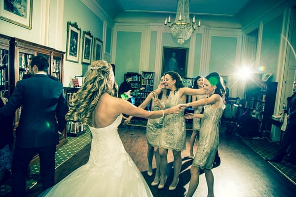 Bride and bridesmaids dancing in Library at The In and Out