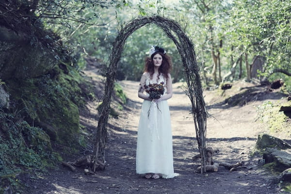 Bride standing by arch