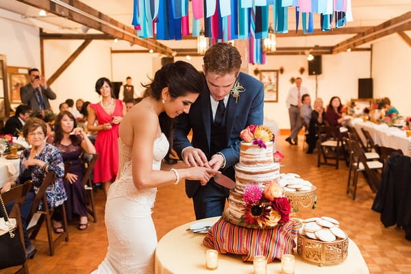 Bride and groom cutting wedding cake